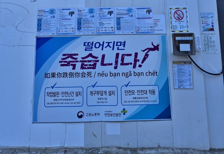다국어로 병기된 안전 안내문과 소음·미세먼지 정보판. 외국인 노동자 비중이 높은 현장에서, 이들을 고려한 안내 체계가 점차 확대되고 있다.